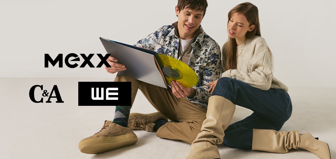 Mladý muž a žena sedí na podlaze a společně se dívají na žlutou vinylovou desku a její obal na jednobarevném pozadí.