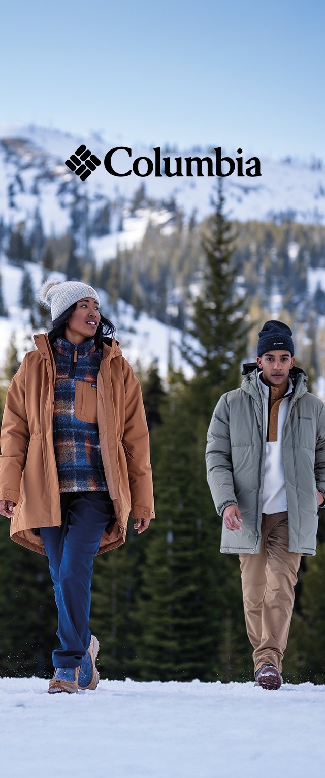Dos individuos caminan en un paisaje nevado. Uno lleva un abrigo marrón sobre un suéter a cuadros; el otro lleva una chaqueta verde claro con detalles marrones.