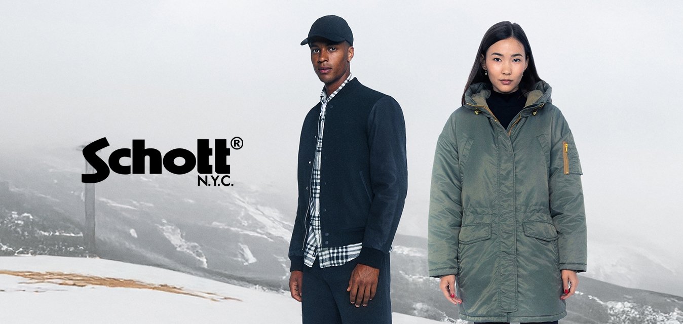 Dva jedinci stojí na zasněženém terénu. Muž má na sobě tmavý bomber a kostkovanou košili, zatímco žena má na sobě zelenou bundu s kapucí.