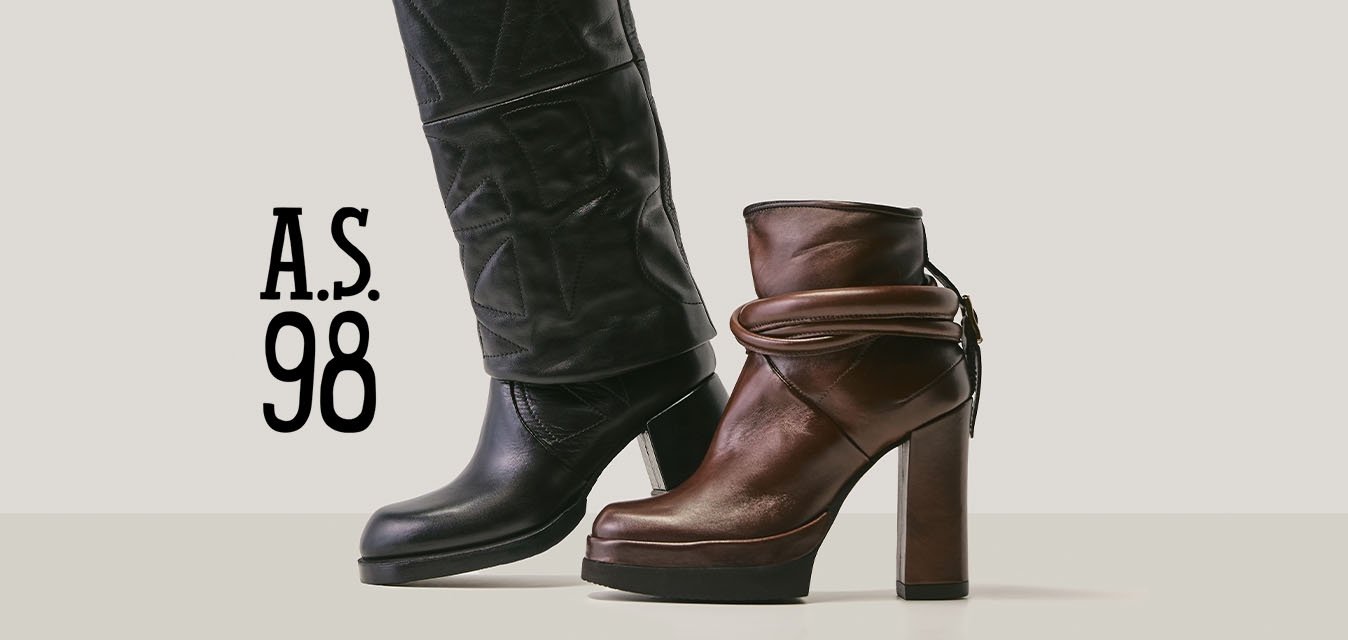 Vysoká černá kožená bota s texturovaným vzorem vedle středně vysoké hnědé kožené kotníkové boty na podpatku s detailem omotaného pásku.