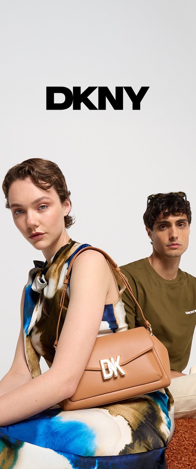 Tan leather handbag with gold DK logo, featuring a rectangular shape and shoulder strap. Model wears a floral dress with blue and brown tones.