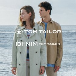 Světle zelený trench coat, béžová košile, bílé kalhoty a hnědé boty. Oba kousky jsou neformální, s měkkými texturami na pozadí kamenité pláže.