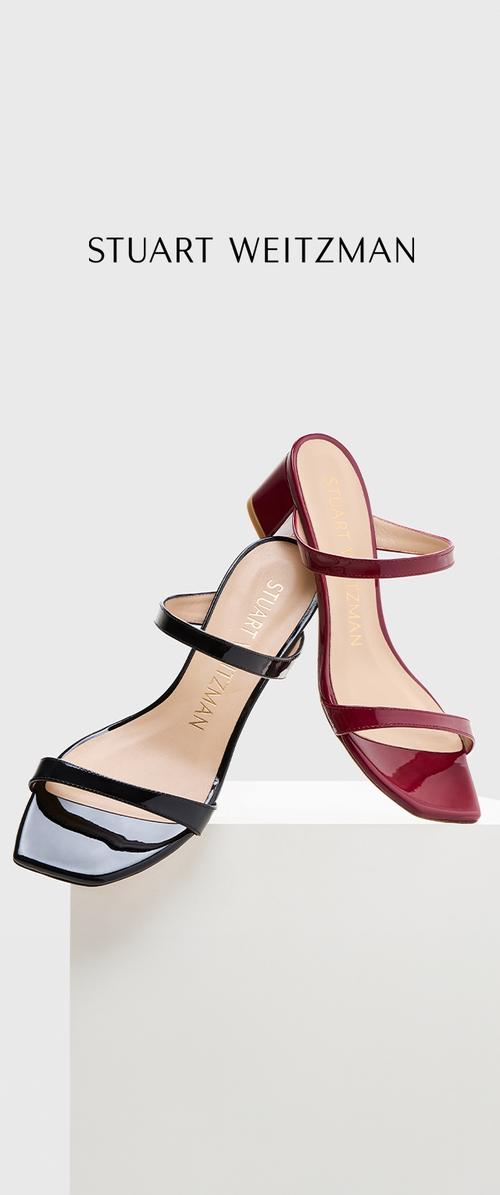 Sandalias de tacón con tiras en charol negro y charol burdeos. Presentan una punta cuadrada y un tacón bloque de altura media.