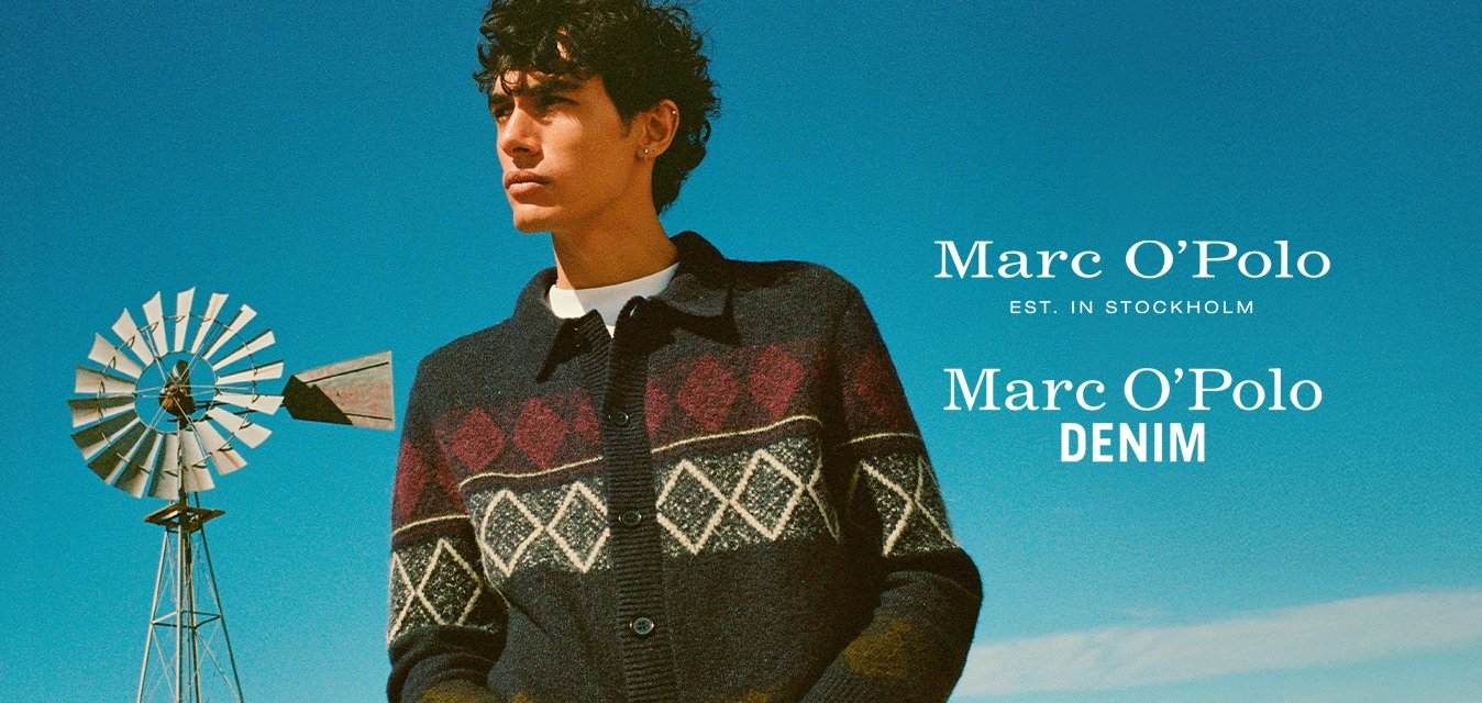 Námořnický kardigan s vzorovanými červenými a bílými diamanty, zapínání na knoflíky, s límečkem a žebrovanými manžetami. Model stojí proti modré obloze.