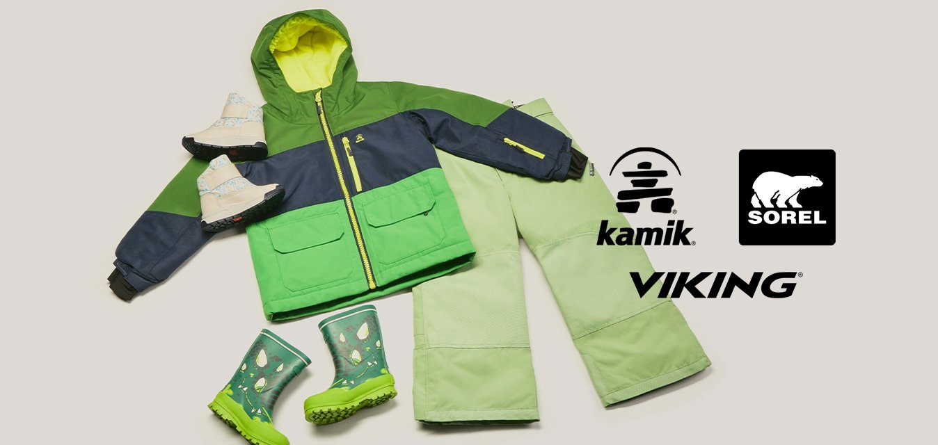 Zelená a tmavě modrá zimní bunda s limetkovou podšívkou, světle zelené sněhové kalhoty, zelené gumové boty s vzorem a bílé zimní rukavice uložené vedle sebe.