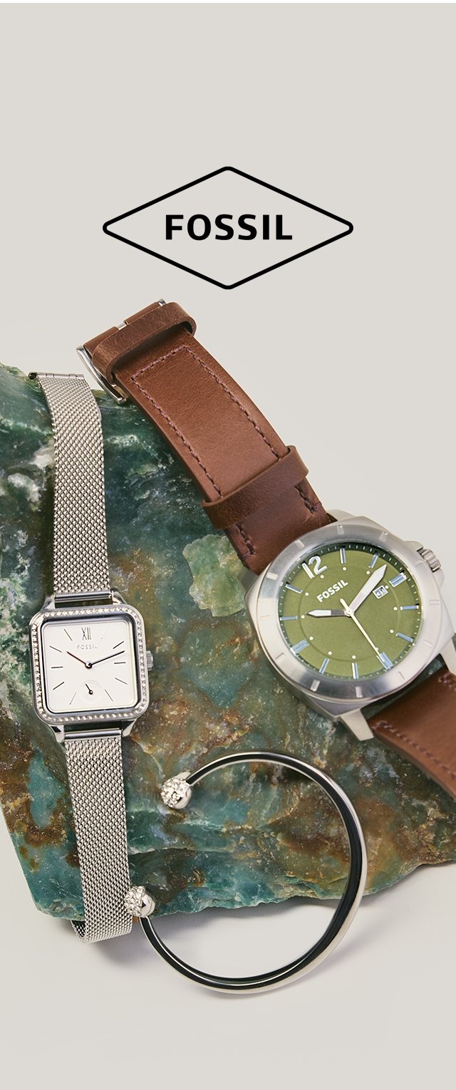 Dos relojes Fossil y una pulsera de plata exhibidos sobre una piedra marmoleada verde, con una correa de cuero marrón y un reloj con correa de malla plateada.