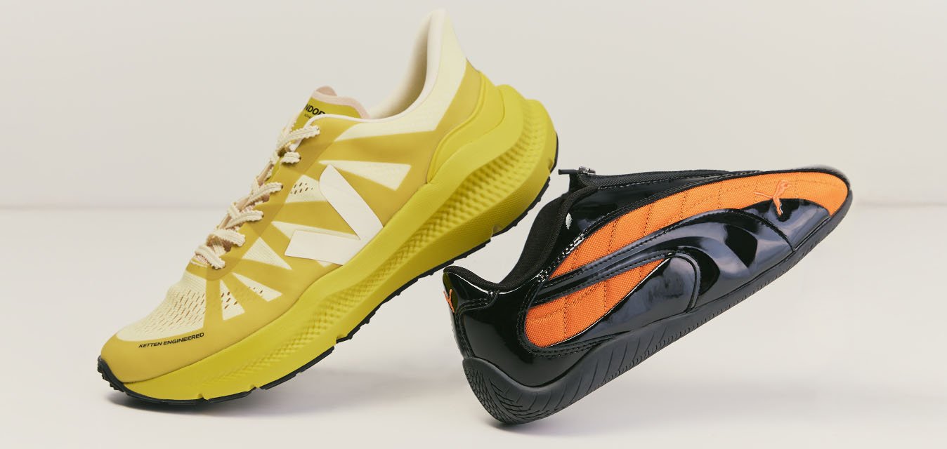 Žlutá běžecká bota a černá nazouvací teniska s oranžovými detaily postavené vedle sebe na jednoduchém, světlém pozadí.
