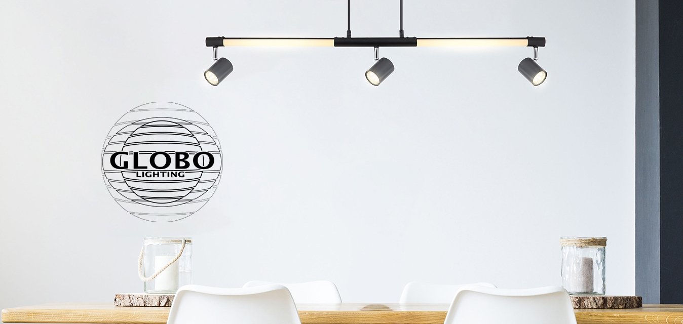 Lineární černé závěsné světlo s dvěma nastavitelnými reflektory nad dřevěným stolem. Bílé židle s přírodními dřevěnými nohami a růžová váza s květinami.