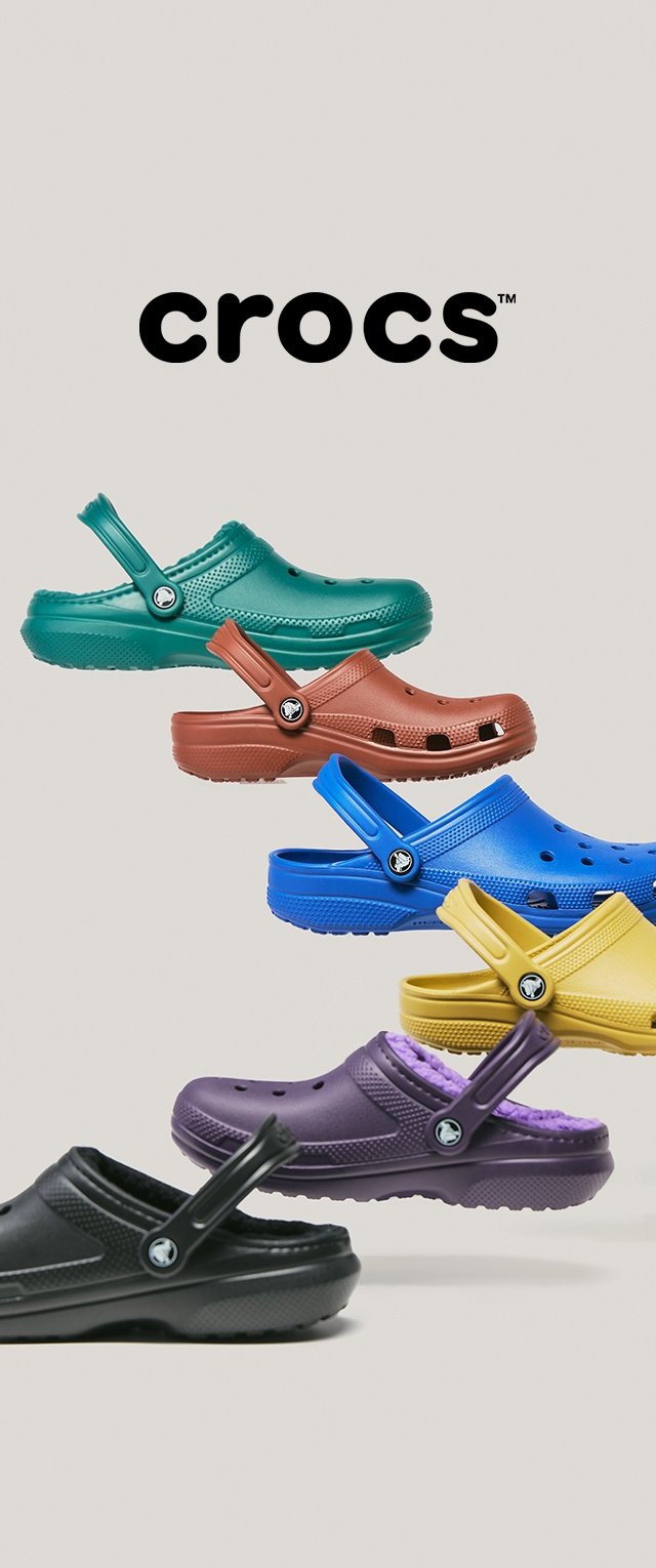 Zes kleurrijke Crocs klompen diagonaal gestapeld met het Crocs-logo centraal erboven op een effen achtergrond.