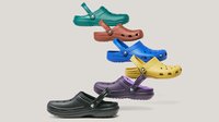 Sechs bunte Clogs im stapelnden diagonalen Layout, mit Belüftungslöchern und Fersenriemen, auf einem schlichten hellen Hintergrund.