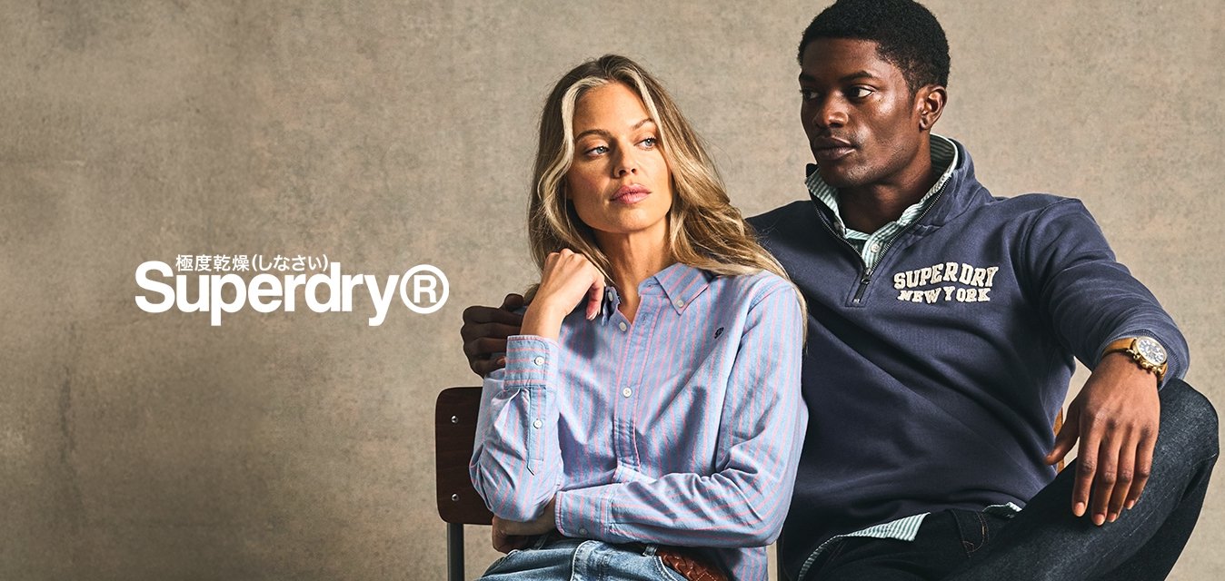 Dva sedící jednotlivci na židli. Jeden má na sobě světle modrou pruhovanou košili na knoflíky a modré džíny; druhý má tmavě modrý svetr a tmavé džíny.