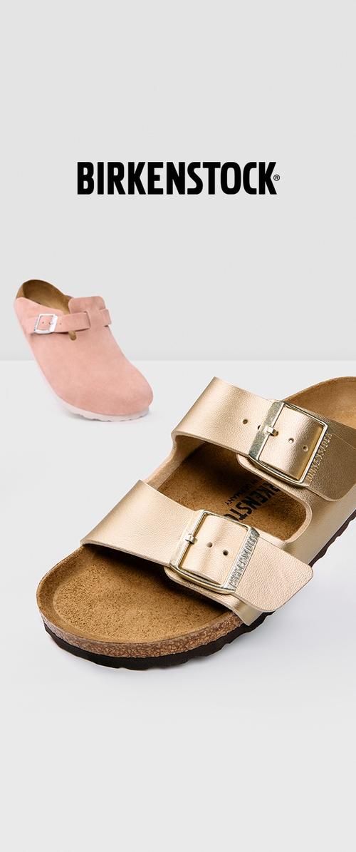 Gouden leren sandalen met twee verstelbare banden, kurken voetbed, gestructureerde zool en een roze suède klomp op de achtergrond.