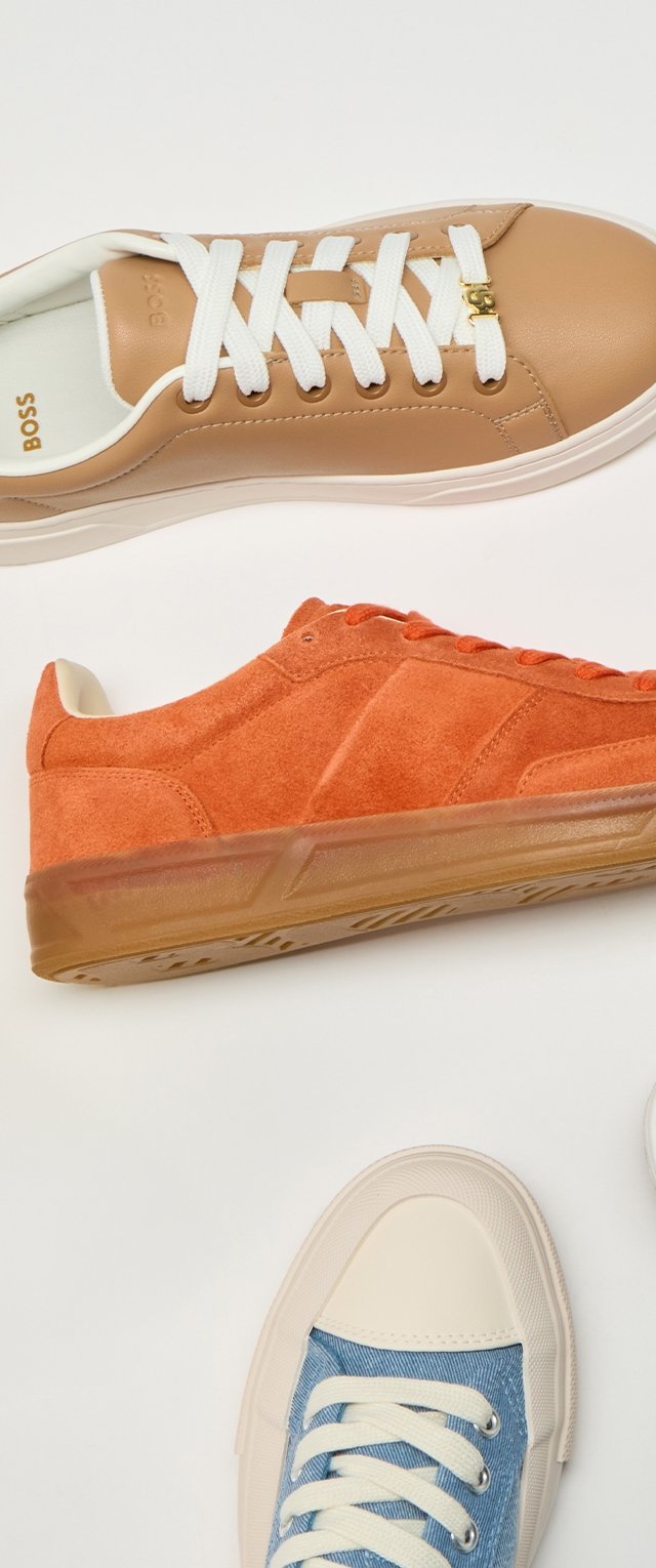 Tre scarpe da ginnastica disposte verticalmente: in pelle beige con lacci bianchi, in suede arancione con suola in gomma, in tela blu con punta e lacci bianchi.