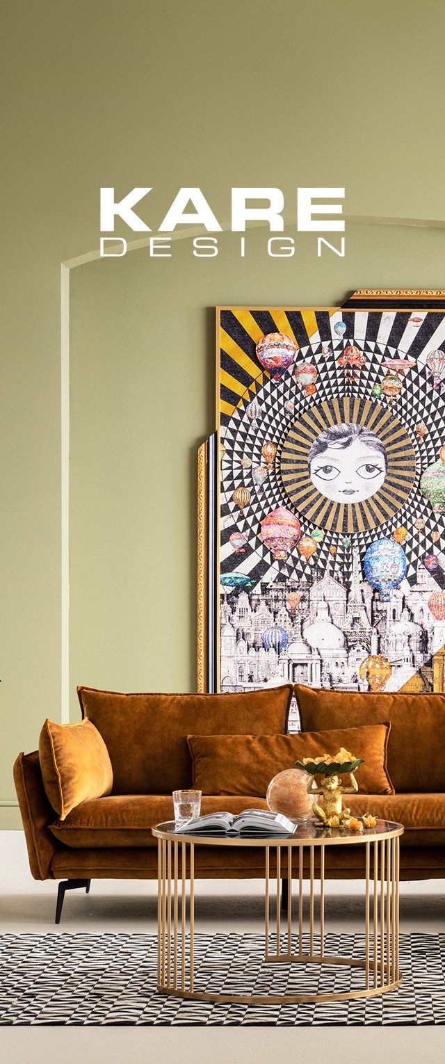 Canapé en velours marron avec des accoudoirs arrondis, table basse en métal doré rond avec des lattes verticales, tapis noir et blanc à motifs, et art mural coloré.
