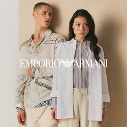 Dvě osoby stojí před béžovým panelem, jedna má na sobě vzorovanou košili a krémové kalhoty, druhá bílý blejzr a volné krémové kalhoty.