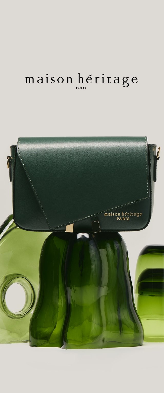 Bolso de mano de cuero verde oscuro con cierre dorado y logo "maison héritage PARIS", exhibido sobre esculturas de vidrio verde de formas irregulares.