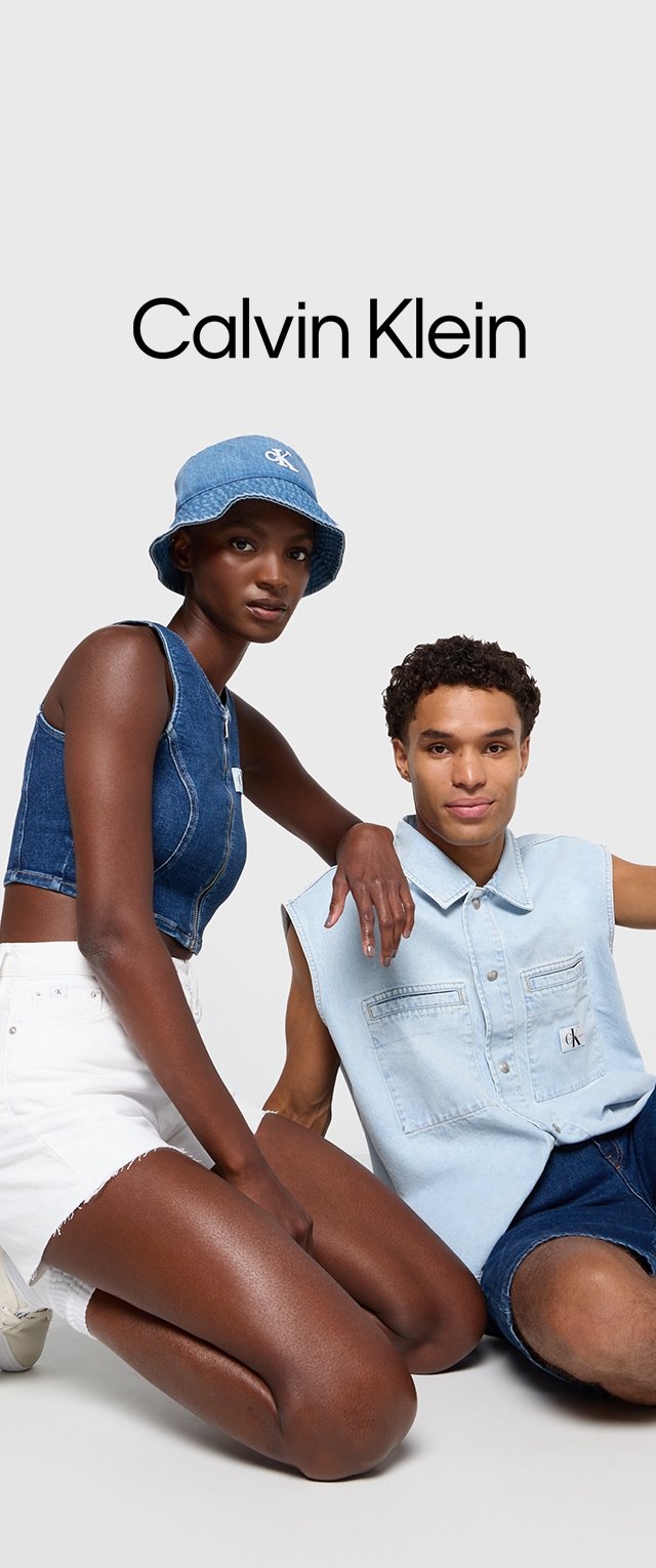 Top corto in denim e pantaloncini con orli sfilacciati di un blu chiaro; cappello a secchiello blu; modello maschile in camicia senza maniche di denim chiaro.