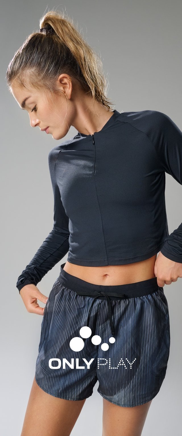 Zwarte cropped top met lange mouwen gecombineerd met marineblauwe gestreepte shorts met een elastische tailleband en trekkoord. Logo zichtbaar op de shorts.