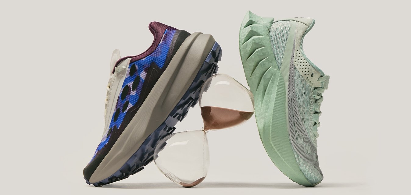 Dva sportovní boty, jeden modrý s kamuflážním vzorem a jeden světle zelený, vyvážené na naskládaných skleněných objektech na jednoduchém pozadí.