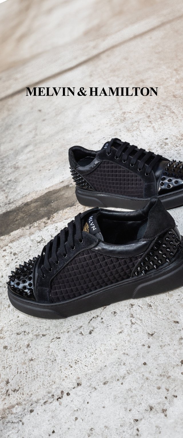 Schwarze Sneakers mit einer strukturierten, gesteppten Oberseite, verziert mit metallischen Stacheln an der Ferse. Gummisohle, Schnürdesign und Logodetail.