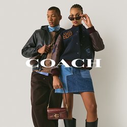 Dva modelky pózují před obyčejnou zdí; jedna v kožené bundě, hnědých kalhotách a teniskách, druhá ve varsity bundě, džínové sukni, botách a slunečních brýlích.