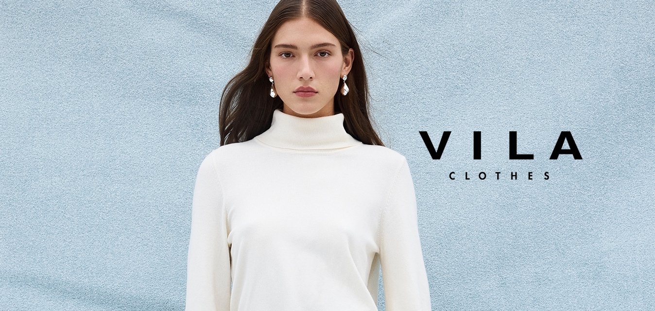 Bílý rolákový svetrový šaty s dlouhými rukávy a ladícím opaskem. Kombinované se šedými punčocháči a béžovými vysokými kozačkami na podpatku.