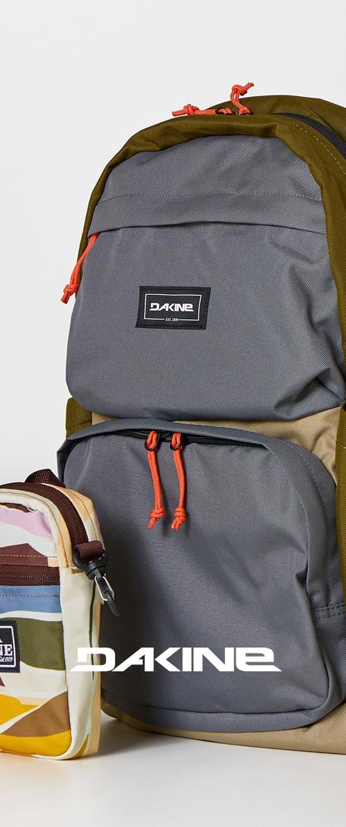 Grau-olivfarbener Dakine-Rucksack mit orangen Reißverschlussösen neben einem mehrfarbigen Dakine-Beutel auf einem weißen Hintergrund.