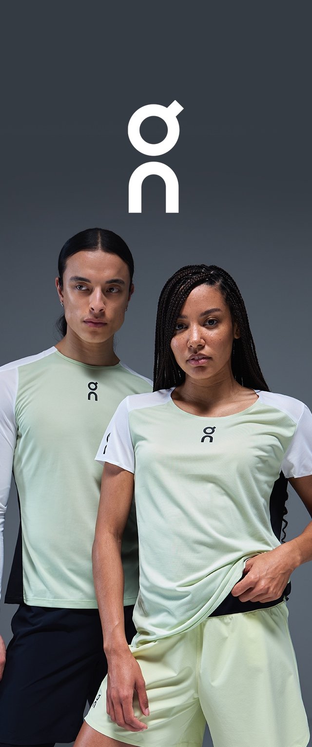 Camisetas deportivas verde claro con mangas blancas y detalles en negro, con el logo en el pecho. Modelo vistiendo pantalones cortos a juego.