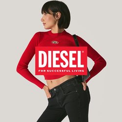 Žena pózující v černých rozšířených džínách, červeném dlouhém topu na břicho, černých sandálech a držící černou kabelku přes rameno na jednolitém pozadí.