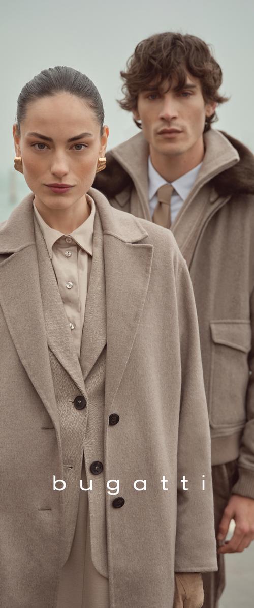 Abrigo de lana beige con grandes botones, superpuesto a un chaleco y camisa claros. Hombre con chaqueta gris suave con detalles acanalados al fondo.