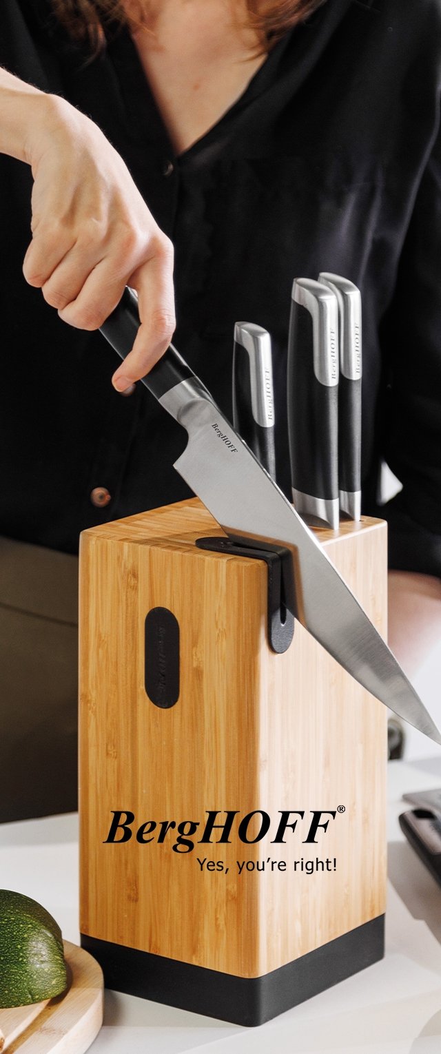 Bloque de cuchillos de bambú con cinco cuchillos de acero inoxidable, con mangos negros y una base antideslizante. Incluye un gran cuchillo de chef en uso.