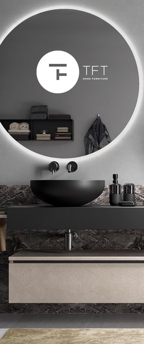 Zwarte ronde wastafel boven een gestructureerde beige wastafel. De muur heeft een grote ronde spiegel met achtergrondverlichting. Donker marmeren achterwand met accessoires.
