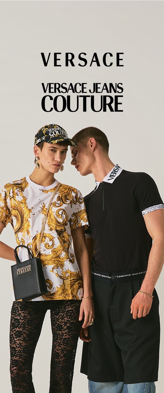 Deux mannequins posent vêtus de Versace Jeans Couture : l'un porte une chemise imprimée baroque, une casquette, un pantalon en dentelle et un sac à main ; l'autre un polo noir et un short.