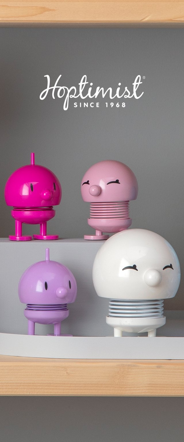 Cuatro figuras decorativas en rosa, púrpura y blanco, con formas redondas y distintivas caras sonrientes; presentan cuerpos y bases con texturas únicas.