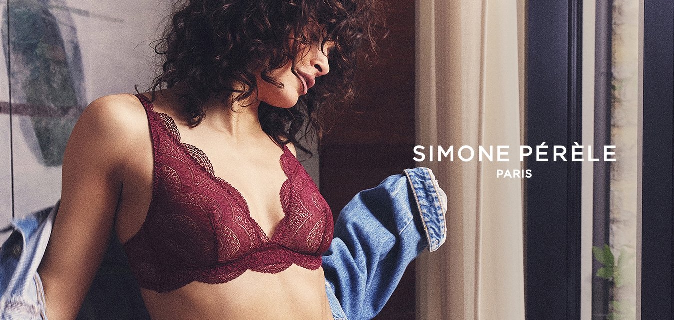 Burgundská krajková braletka a odpovídající bikiny, s vlnitými okraji a měkkou texturou, držené s džínovou bundou přehozenou přes jedno rameno.