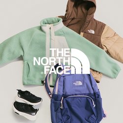 Zelená fleece bunda, hnědá a béžová péřová bunda, modrý batoh a černé sportovní boty uspořádané na světlém pozadí.