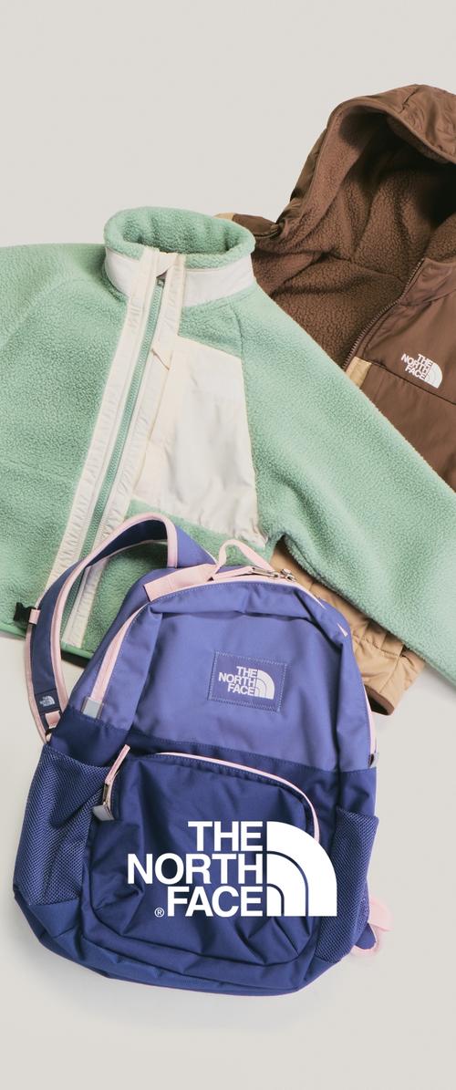 Två fleecejackor, en grön och vit, en brun med huva, och en blå ryggsäck med ljusrosa detaljer, alla märkta The North Face.