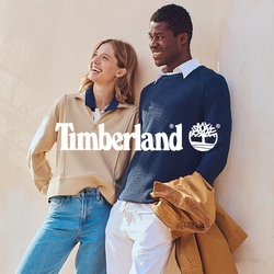 Béžový svetr na zip s modrým límečkem; námořnicky modrý žebrovaný svetr; světle modré džíny; hnědé boty; bílé kalhoty; hnědá bunda; texturovaná zeď; zelené okenice.