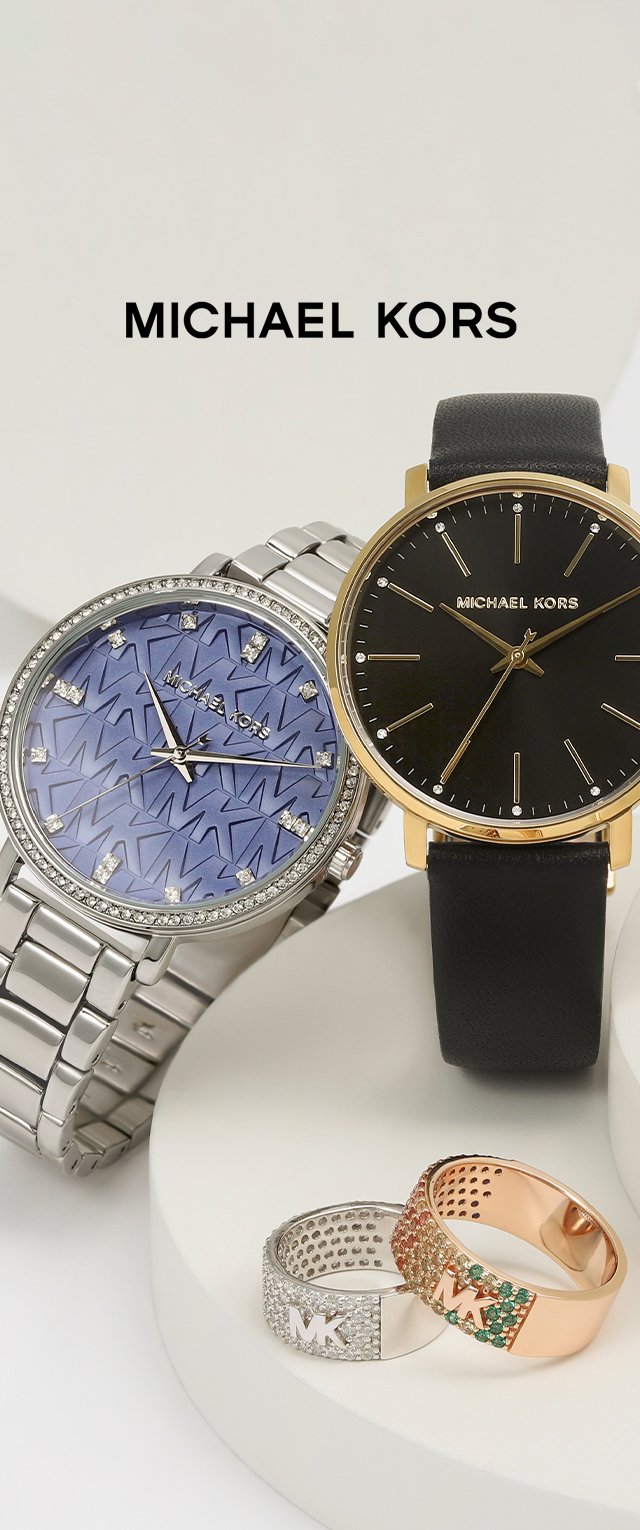 Dwa zegarki Michael Kors: jeden z srebrną bransoletą i niebieską wzorzystą tarczą, drugi z czarnym skórzanym paskiem i złotą kopertą. Dwa pierścionki z akcentami.