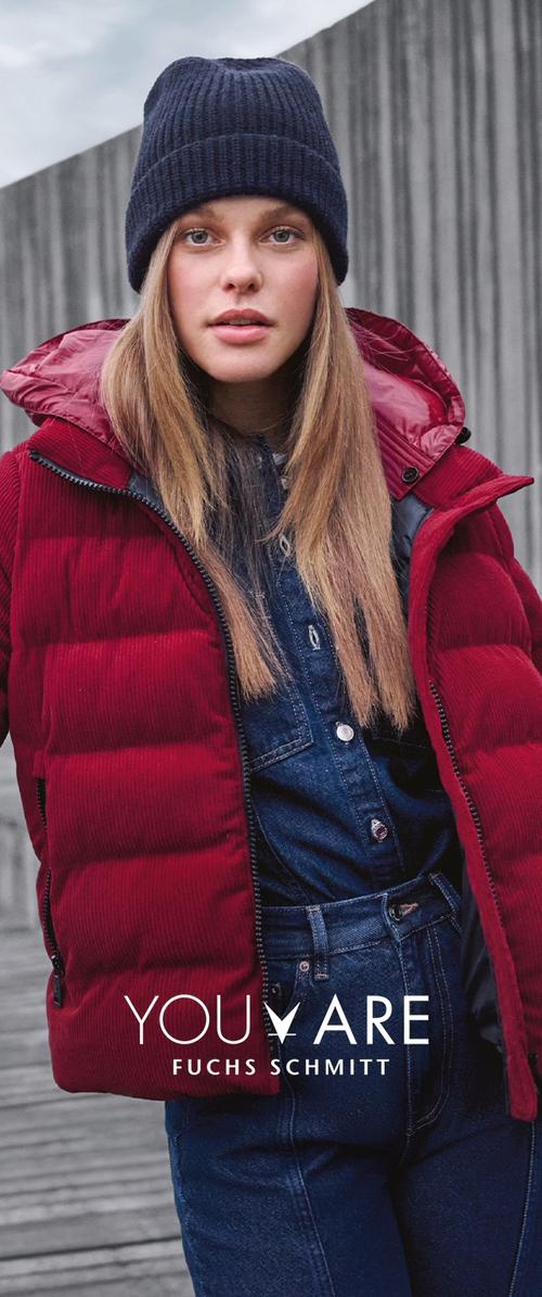 Chaqueta de plumas de corduroy rojo con capucha, gorro de punto negro con canalé y camisa de denim. La chaqueta cuenta con una cremallera y está acolchada para proporcionar calor.
