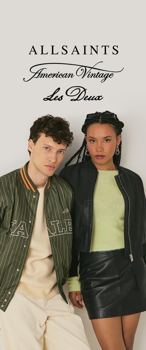 Joven con chaqueta verde a rayas y pantalones crema está junto a una mujer con chaqueta de cuero negra, suéter verde y falda negra sobre un fondo blanco.