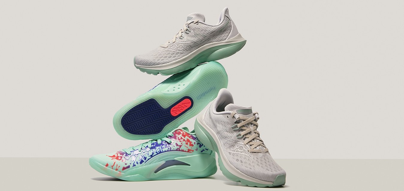 Světlé šedé sportovní boty s texturovanými síťovanými svršky, měkkou zelenou podrážkou a vícolorovým abstraktním vzorem na dolní části boty.