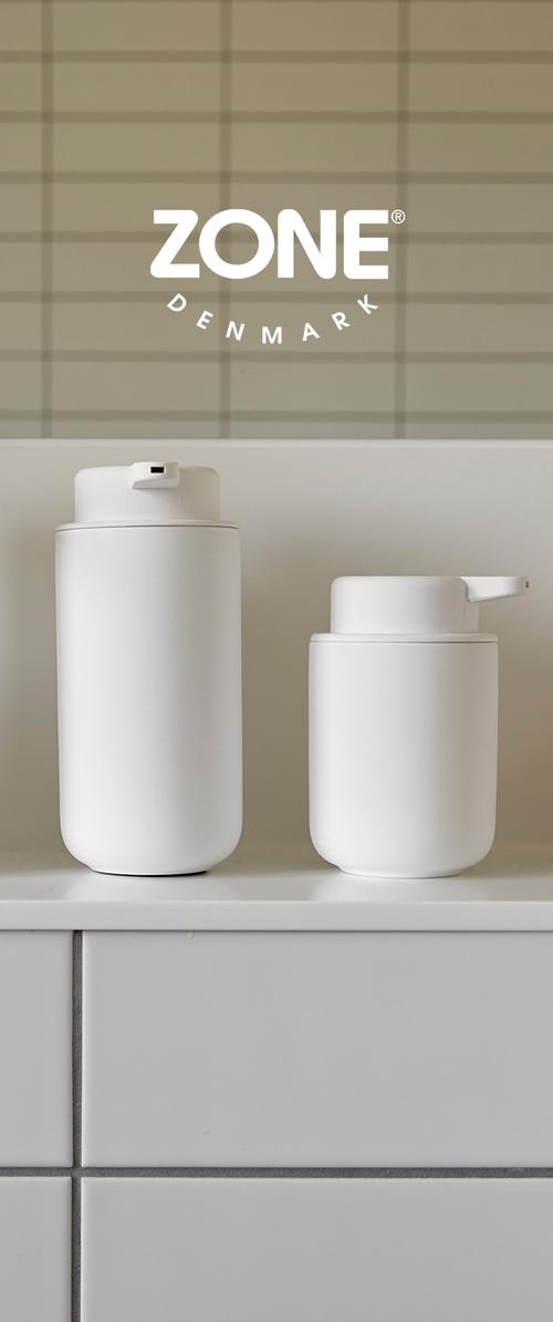 Dos recipientes cilíndricos, blancos, hechos de un material liso; uno tiene una tapa abatible, el otro tiene un pico vertedor. Diseño simple y minimalista.