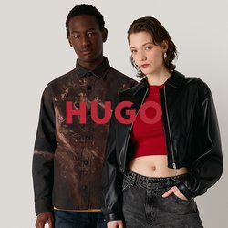 Dvě modelky stojí na neutrálním pozadí. Jedna má na sobě vzorovanou hnědou košili a modré džíny, druhá černou zkrácenou bundu a šedé kalhoty.