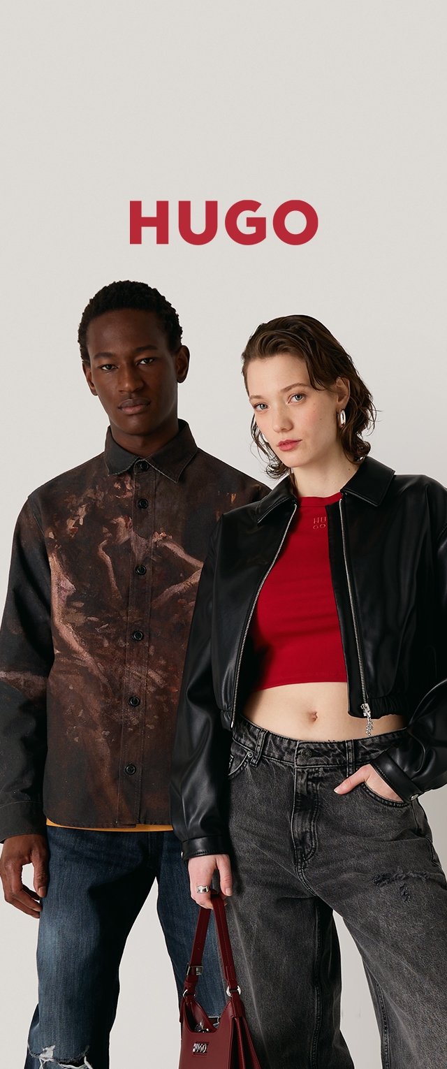 Due modelli indossano abbigliamenti distintivi: una camicia scura a fantasia, jeans robusti, una giacca di pelle nera e un top corto rosso, abbinati a una borsa.