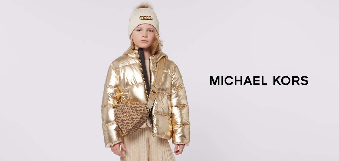 Zlatá péřová bunda, černý vnitřní kabát, béžová plisovaná sukně, hnědá kabelka přes rameno s logem a černé boty se zlatými detaily.