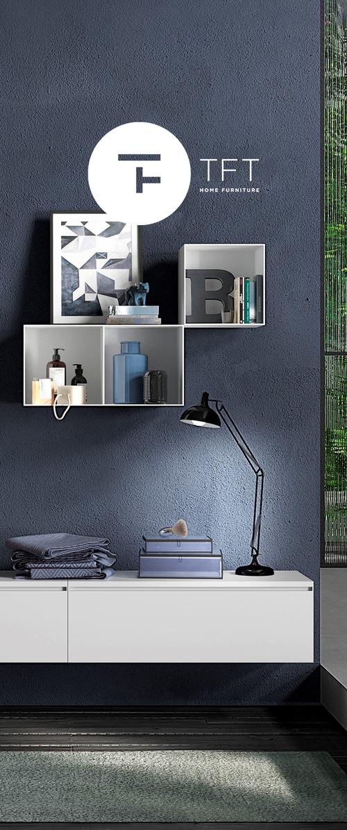 Pared texturizada azul oscuro con estantes flotantes blancos que sostienen objetos decorativos, gabinete blanco debajo con textiles doblados y una lámpara de escritorio negra ajustable.