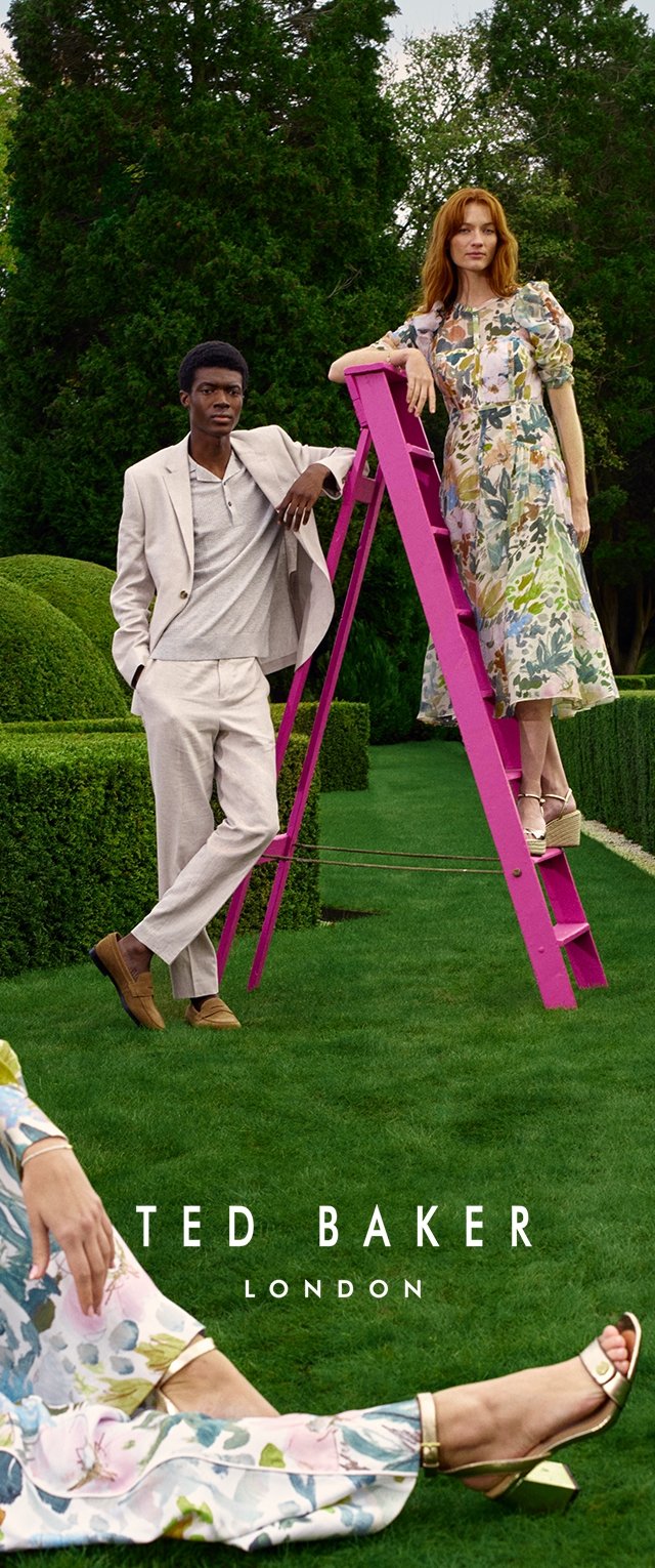 Dos modelos posaron al aire libre: uno en un traje claro con un suéter, el otro en un vestido floral. Una escalera rosa brillante se encuentra entre ellos.