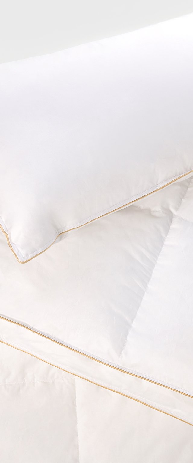 Weißes Bettwäsche-Set mit einem glatten, steppbaren Bettdecken und einem Kissen mit einem subtilen goldenen Saum, das ein sauberes, minimalistisches Design betont.