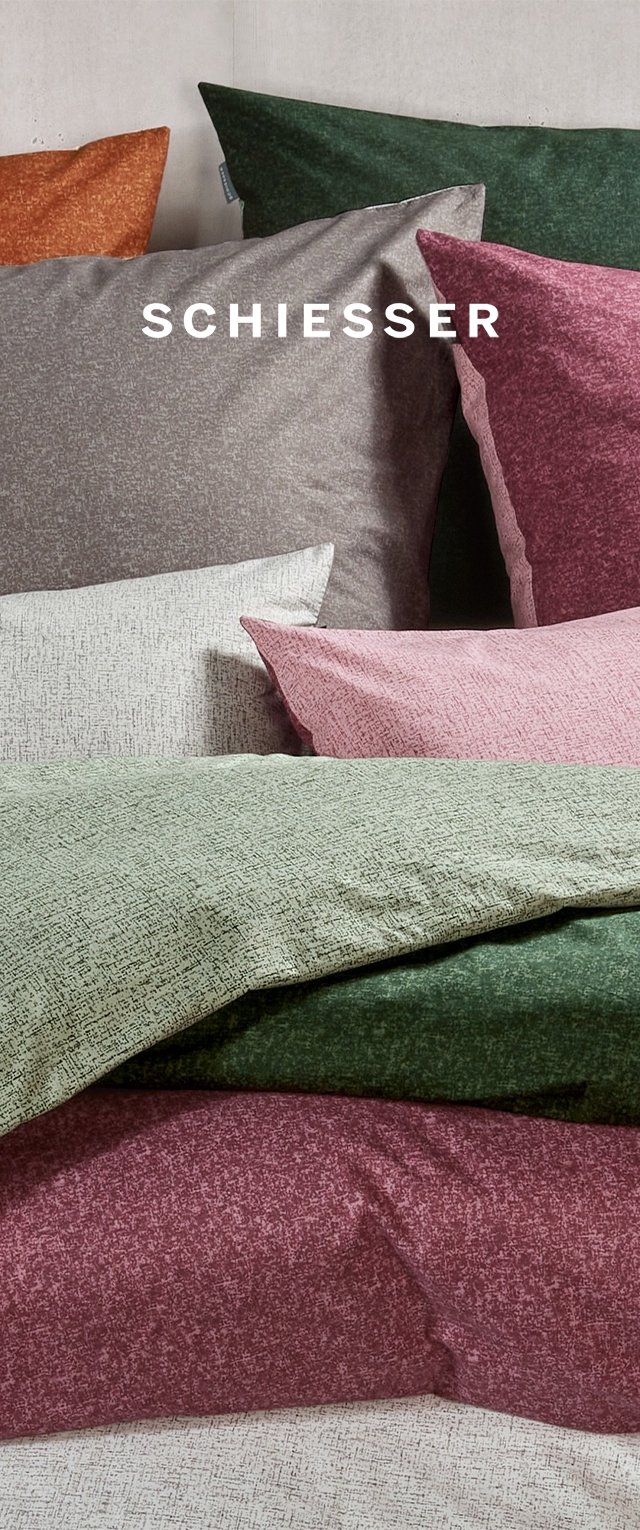 Textured fabric pillow covers in varied colors: olive green, burgundy, light grey, dark grey, and orange. Brand name "Schiesser" prominently displayed.